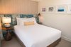Modern home with Pendant Lighting, Table Lighting, and Lamps. The bedrooms are graced with headboards that The Vanguard Theory created with vintage Tori Richard prints. The dreamy framed surf photography on the wall is by She Hit Pause Studios. Photo 12 of The Surfjack Hotel & Swim Club