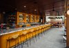 Modern home with Dining Room, Concrete Floor, Stools, and Bar. The bar is lined with vintage bar stools by Arthur Umanoff, which OMFGCO sourced from all over the world via 1stdibs, Pamono, and Etsy. Fritz Mesenbrink of OMFGCO tells us, “It was challenging to get that many of his stools in the same place, but we got them and had them all restored beautifully.” Photo 7 of The Laylow