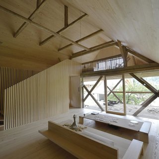 In an area of rural Slovenia that is dotted by dilapidated farmhouses and barns, the Alpine Barn Apartment is an homage to these traditional structures, saving the original exterior of a vernacular barn and transforming it into a modern loft. The home’s rustic origins were not lost in the modern adaptation of the interior space. Raw wooden floors and walls pair well with minimal furniture of the same hue, towered over by the original rafters that span the high-ceilings. <span style="color: rgb(204, 204, 204); font-size: 13px;">© Tomaz Gregoric</span>