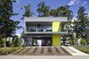 From the street a vegetated drive bridges the site to the vehicular "pad". From here a semi-enclosed bridge extends through the trees to the wood clad main house beyond. The seasonably closable upper guest house protects the cars in an unconditioned porte-cochere concealed by enormous folding translucent panel doors.
#garage #portecochere #beachhouse #driveway #vegetation #guesthouse #beachhouses #britishcolumbia #limegreen #color #bright #glass #steel #mineralfinish #landscape #green #interstice #intersticearchitects #residential #residentialarchitecture #danlaughton #danlaughtonphotography
Photo 8 of TreeHugger modern home