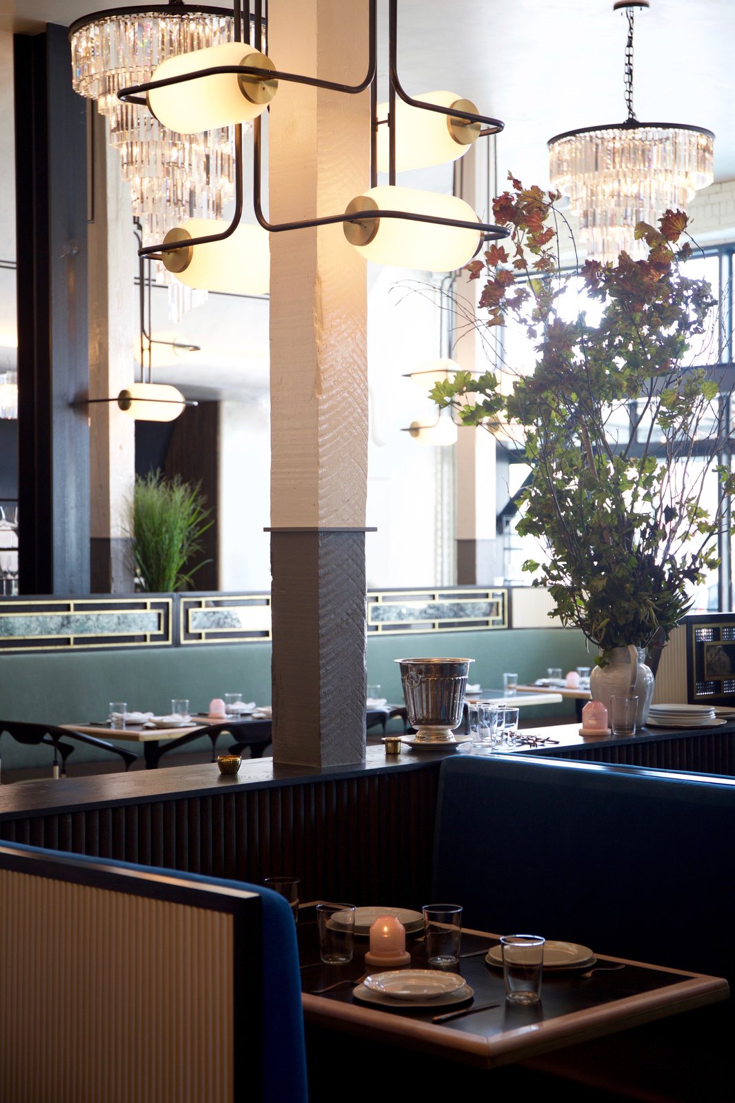 Nearly all of the fixtures, including the black-steel pendants that wrap the columns with opal pill-shaped glass shades, were inspired by the era of glamour evoked by the building's 1920s history.