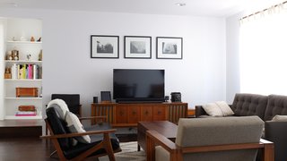 The living room is outfitted with a Petrie sofa from Crate &amp; Barrel and a leather love seat from Room &amp; Board. The armchair and console are vintage.