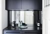 Modern home with Kitchen. In a compact apartment in Australia, the kitchenette uses a mirrored take on the glass backsplash to bring in an element that would reflect light (and views). The mirrored backsplash is relatively easy to clean with the right cleaning tools, but might drive a clean freak a little crazy. Regardless, it's a great contrast to the dark cabinets.
Photo of Nano Pad