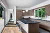 Modern home with Kitchen, Refrigerator, Cooktops, Stone Counter, Medium Hardwood Floor, Ceiling Lighting, and Drop In Sink. Kitchen with indoor outdoor connection Photo 6 of Springs Residence
