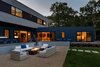 Modern home with Exterior, House, Wood Siding Material, Flat RoofLine, and Prefab Building Type. rear yard and firepit at dusk Photo 15 of Springs Residence