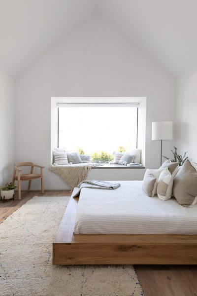 A Casper mattress sits opposite a Klein Agency oak chair in the master suite. A West Elm lamp illuminates the reading nook at night.