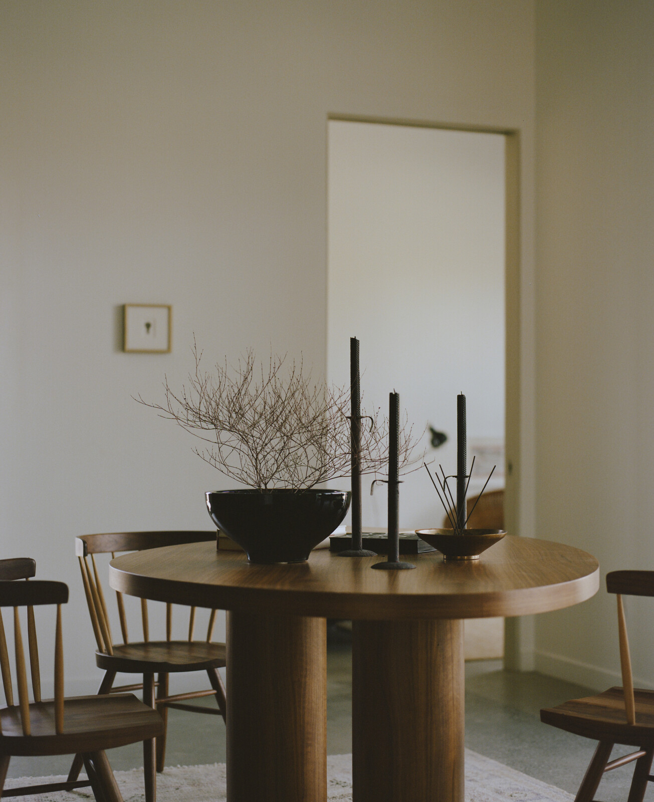 A Big Moon table by James Mitchell Studio is surrounded by Nakashima straight-back chairs.