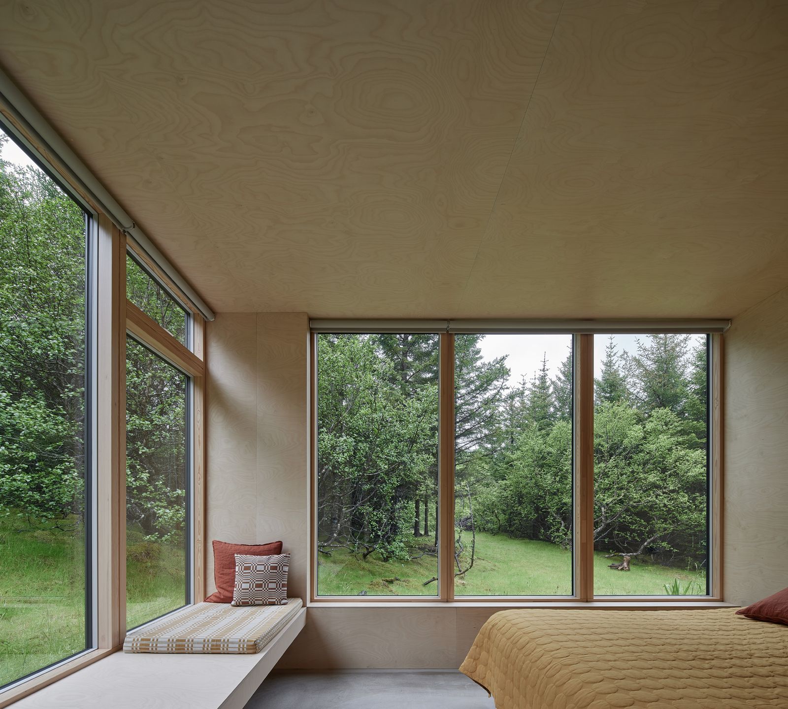 The bedroom has wraparound views of the outdoors.