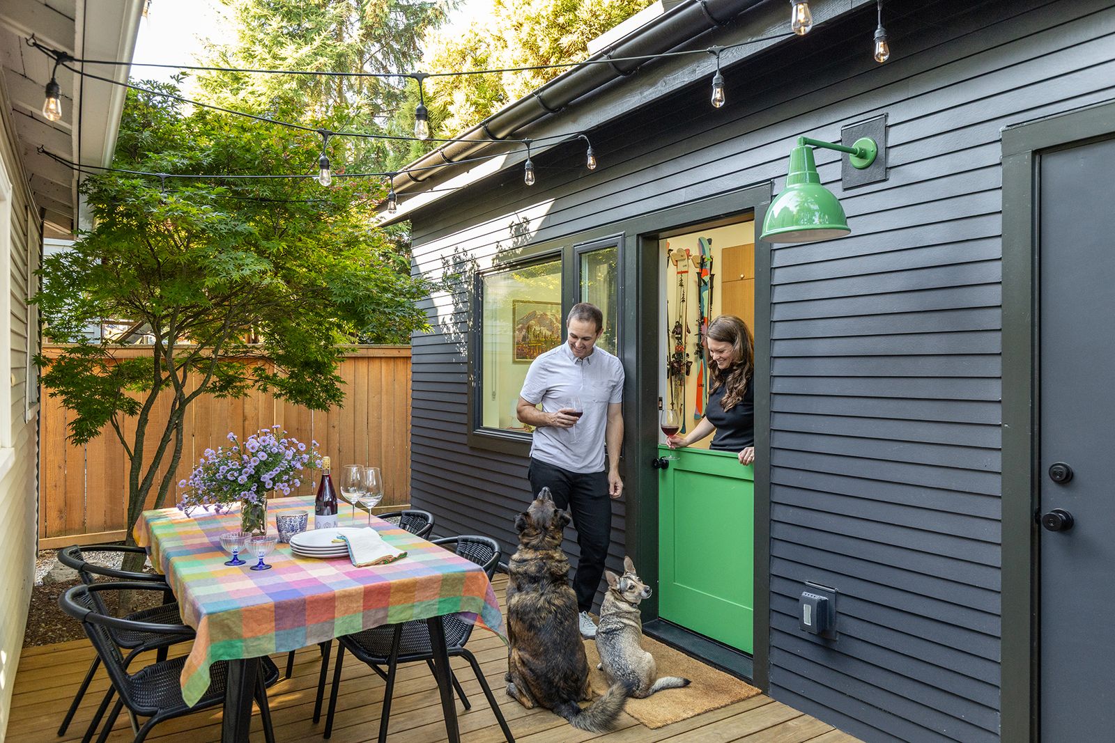 John and Ciera, with their dogs Stanley and Rosie, moved into their Seattle home in 2020. They converted an existing shed into a 180-square-foot flex space when they needed more square footage.  The wood deck is by Kebony, and the CB2 chairs surround a table from Webstaurant Store.