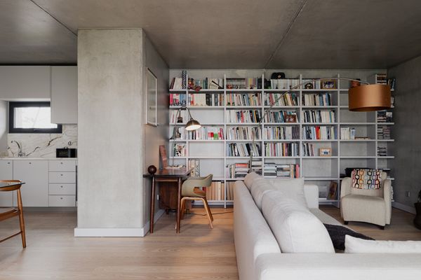 The interior's open floorplan features cozy details like floor-to-ceiling shelving.