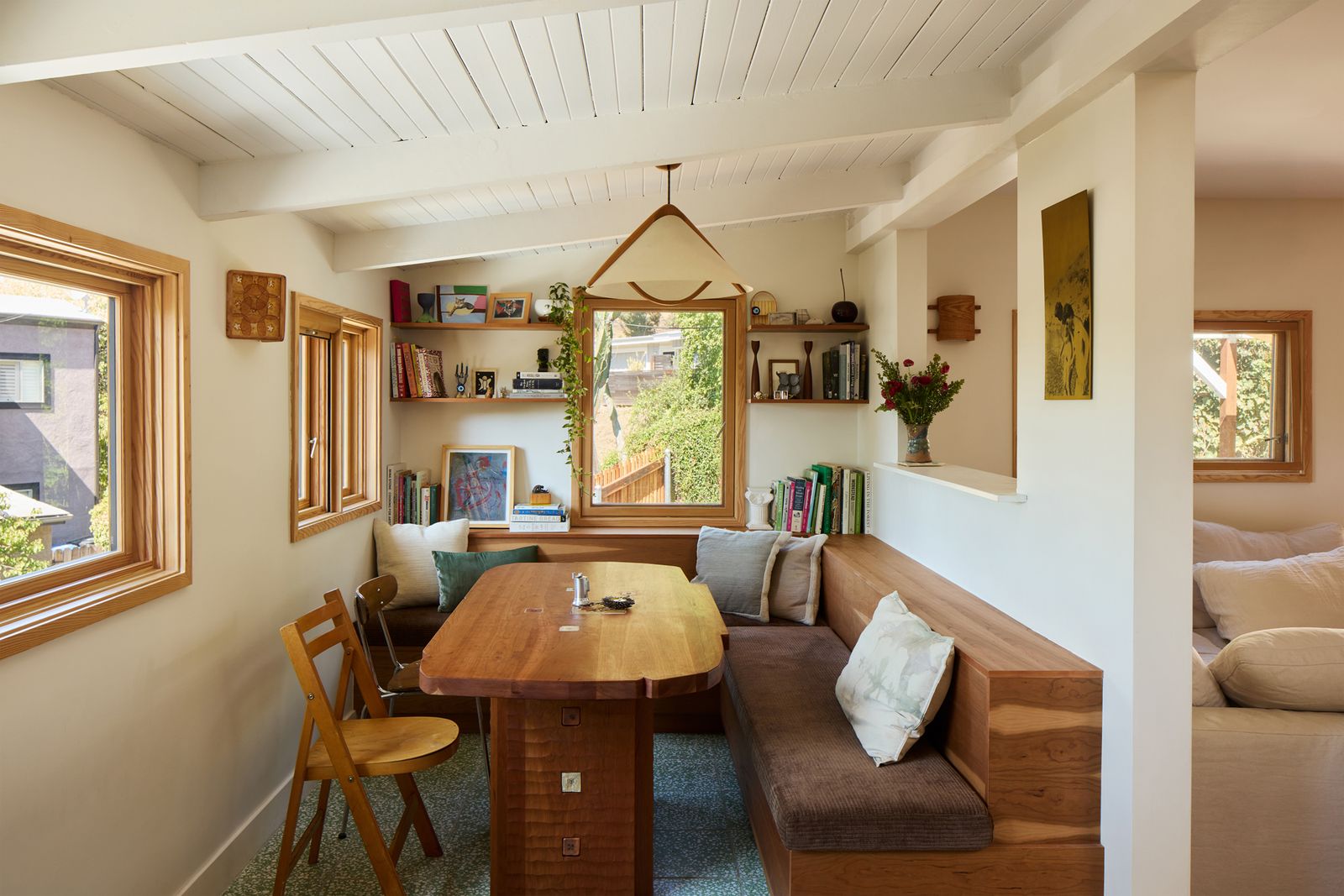 A vintage 1970s pendant hangs above a custom cherry dining table by Mambo Jambo, which features ceramic tiles by Studio Mano.