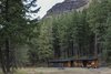 Nestled into the surrounding forest against a dramatic backdrop. Photo of Lot 6 modern home
