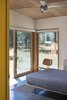 The bedroom opens out onto the deck and meadow beyond. Photo 5 of Lot 6 modern home