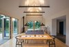 Modern home with Dining Room, Chair, Table, Track Lighting, Pendant Lighting, and Light Hardwood Floor. The "great room" extends out to decks on two sides, creating a cozy yet expansive space for comfortable, easy living. Photo 4 of The Coyle