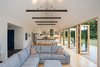Modern home with Living Room, Sofa, Pendant Lighting, Track Lighting, and Light Hardwood Floor. A combination of carefully chosen furniture and finishes, including pine flooring and trim, warms up the lofty white interior. Photo 5 of The Coyle
