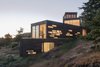 Modern home with Exterior, House Building Type, Green Roof Material, and Wood Siding Material. From below, the volumes seem to cascade down the hillside. Windows light up in a dramatic pattern at night, a sharp contrast to their subtle shapes during the day. Photo of Bailer Hill