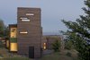 Modern home with Exterior, House Building Type, Green Roof Material, and Wood Siding Material. Viewed from the hill above, the structure rises to peer out over the water while firmly anchored back to the ground. Photo 3 of Bailer Hill