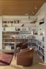 Modern home with Living Room, Chair, Bookcase, Track Lighting, and Light Hardwood Floor. A smaller box just off the main living space is sized just right for a reading room. The clusters of small windows seamlessly morph into horizontal bookshelves. Photo 5 of Bailer Hill