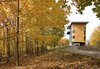 Modern home with Exterior, Metal Roof Material, Metal Siding Material, House Building Type, Flat RoofLine, and Wood Siding Material. Two fin-like, metal-clad walls rise from the crown of the hill to support a three-story plywood box suspended a full story above grade. Photo 2 of Tower House