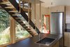 Modern home with Kitchen, Laminate Counter, Wood Cabinet, Refrigerator, Ceiling Lighting, Concrete Floor, and Drop In Sink. An open-tread stair keeps the relatively small space from feeling cluttered or closed off from the view at the entry and kitchen. Photo 5 of Chechaquo