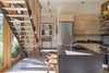 Modern home with Kitchen, Drop In Sink, Refrigerator, Range, Ceiling Lighting, Concrete Floor, Laminate Counter, and Wood Cabinet. The staircase’s open treads and slim, cable railing avoid blocking sight lines outside. A modest material palette, including a concrete floor, wood cabinetry, and charcoal laminate counters, cedes to the views. Photo 6 of Chechaquo