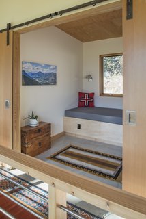 An upstairs reading nook behind sliding doors offers quiet and solitude in the open plan.