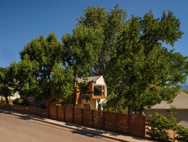 A new fence borders the side of the house, while wood cladding brings a contemporary feel to the additions.