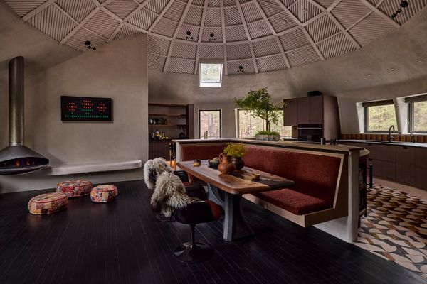 Once awkwardly divided into two spaces by a partial wall, the kitchen-dining room is now open and welcoming, while functioning at a high level for a professional chef. The tile for the kitchen floor is from Pratt + Larson. In the sitting area at left is an Ergofocus gas fireplace by European Home and a Vestaboard programmable artwork.