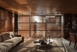 The slatted wood exterior selectively filters sunlight, cooling the interior and creating interesting light and shadow patterns.