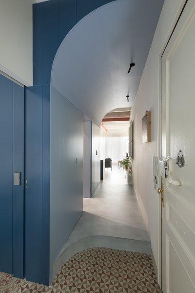 In the corridor between the living room and the bedrooms, light blue hues signal a transition from daytime to nighttime spaces. Serboli preserved the original geometric tile where possible, as in this area of the hallway off the private sleeping quarters.