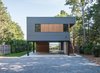 Modern home with Exterior, Flat RoofLine, House Building Type, and Prefab Building Type. Approach via long gravel driveway; Great Peconic Bay seen beyond Photo of North Fork Bay House