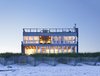 Modern home with House Building Type, Wood Siding Material, Metal Siding Material, Grass, Wood Fences, Wall, Vertical Fences, Wall, Horizontal Fences, Wall, and Bedroom. South elevation at dusk Photo of Dune Road Beach House