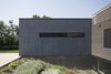 Modern home with Exterior, Prefab Building Type, Flat RoofLine, Wood Siding Material, and House Building Type. Landscaping slopes toward the home, allowing for light to enter the basement / playroom Photo 3 of North Fork Bluff House
