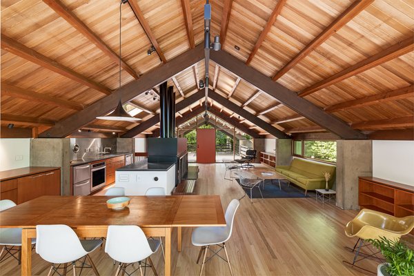 The house’s second floor, where one enters, combines the living, kitchen, and dining areas in one space beneath original architect Richard Campbell’s vaulted wood ceiling.