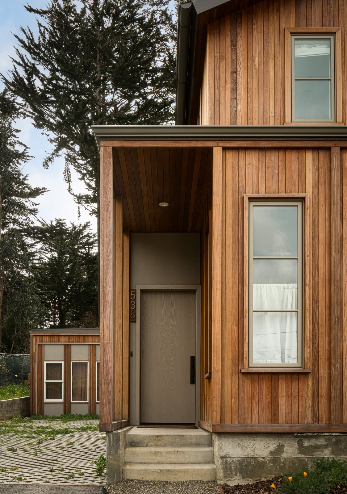 The covered front-door entry repeats the rhythm of window bays on the rest of the front facade.