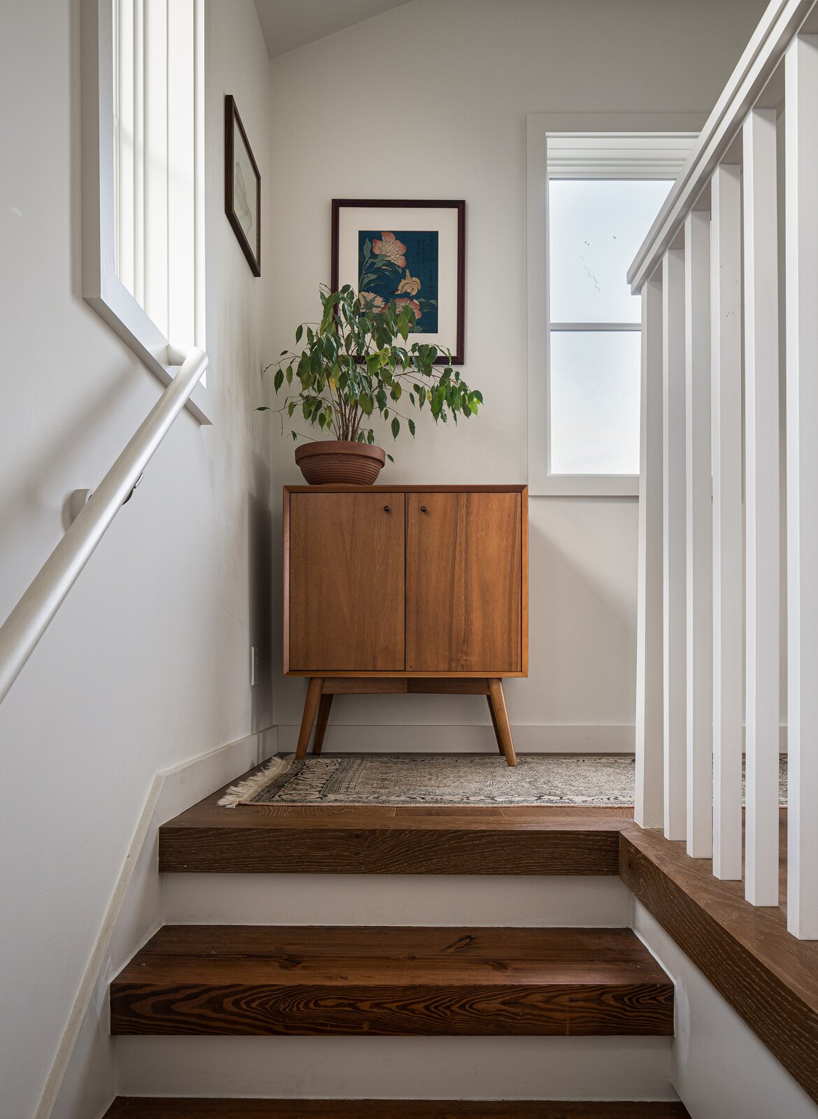 A West Elm cabinet sits at the top of the stairway.