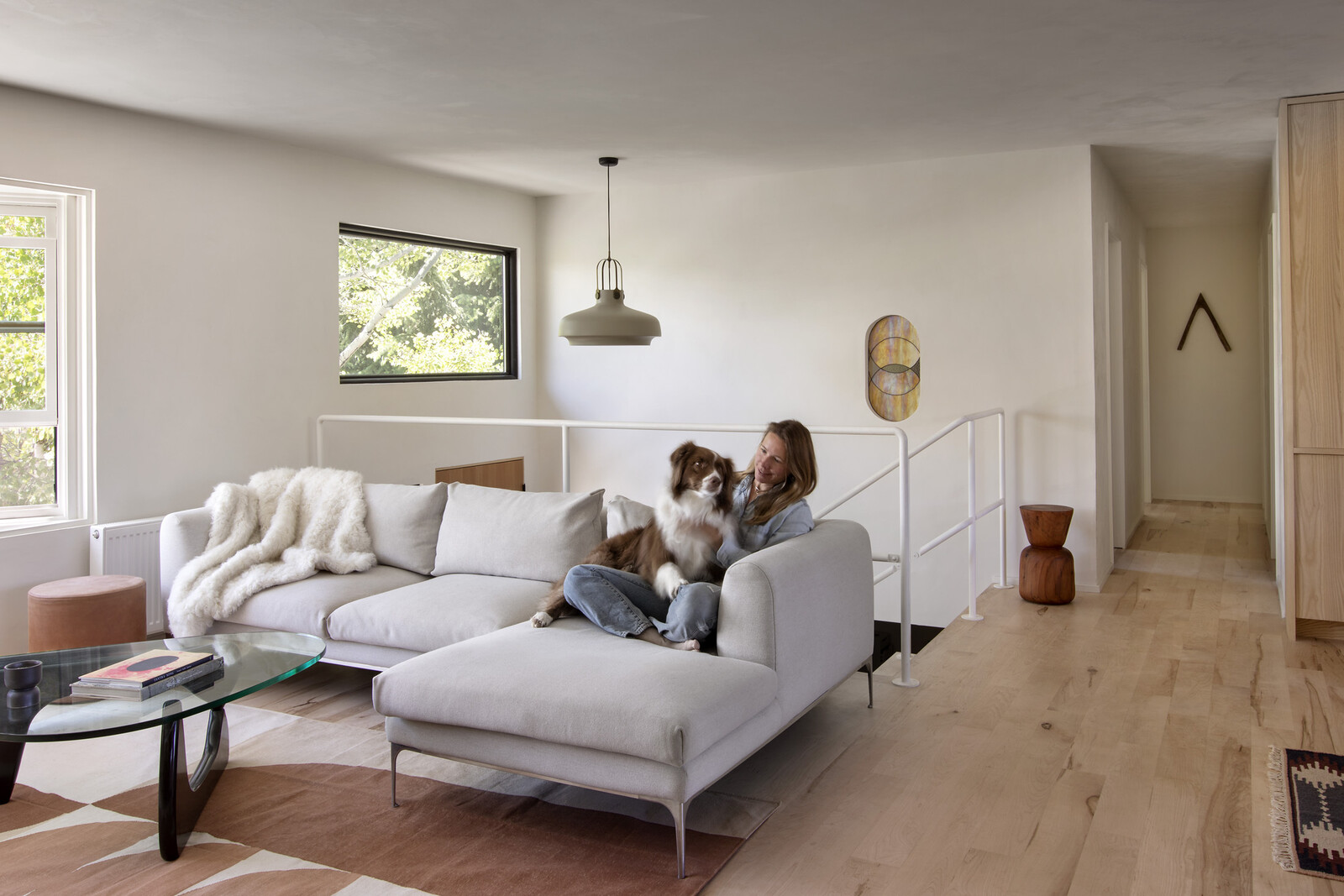 A shot of Allison and her dog Rooby on a Jonas sofa, next to a Noguchi table