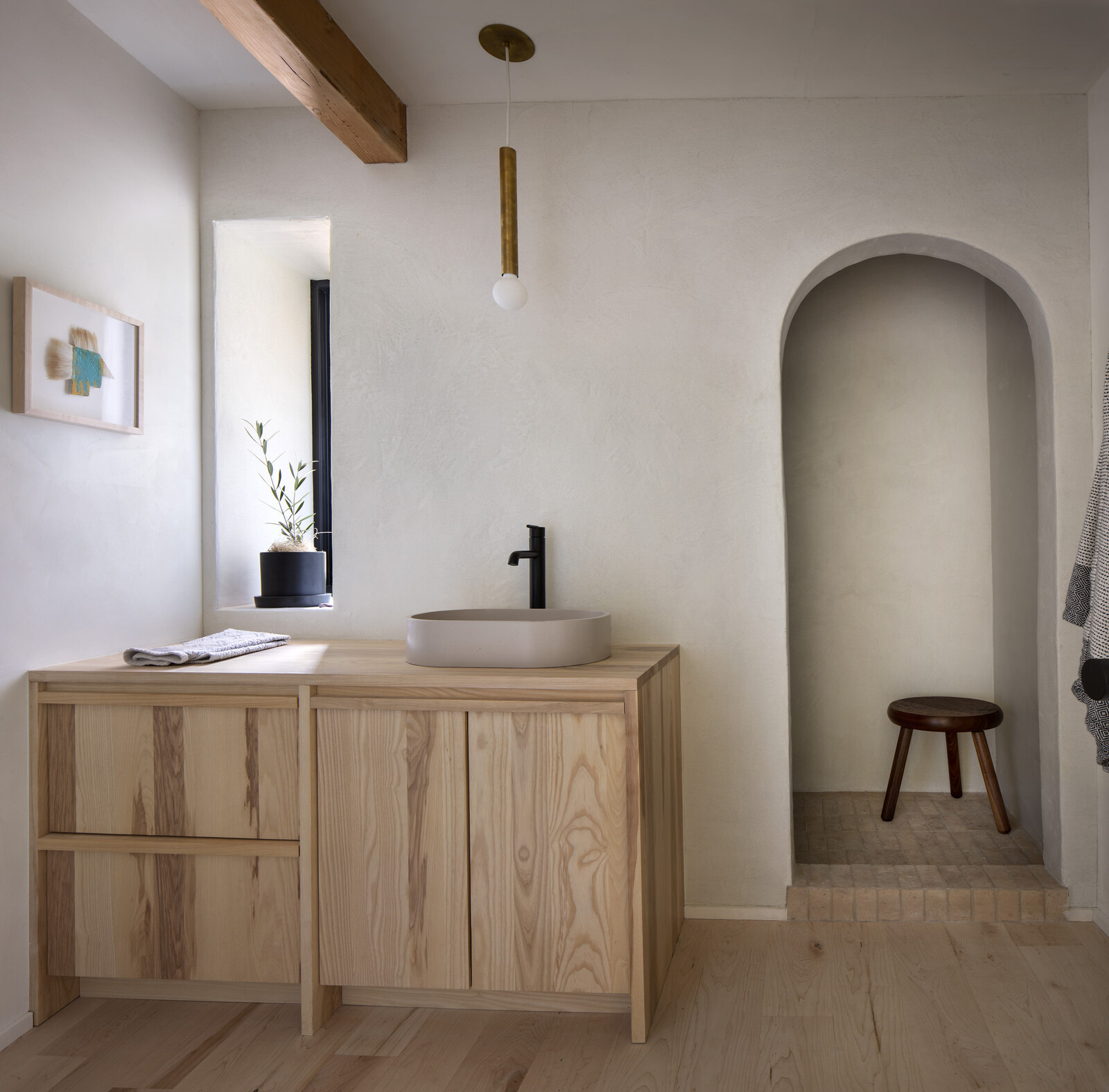 The master suite's bath includes a Sandra Dal Poggetto artwork , custom ash cabinetry from Material, a Mudd sink, a De Jong &amp; co. stool, and a Nash Martinez hanging pendant light.