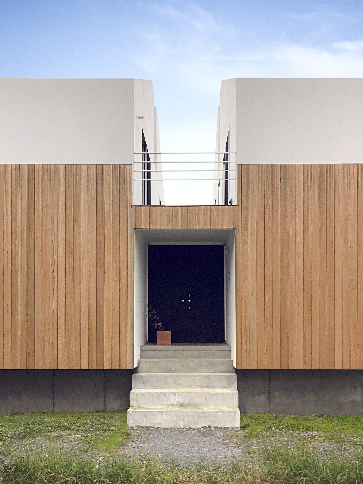 The home's east-facing front side is windowless due to its facing a busy train line.