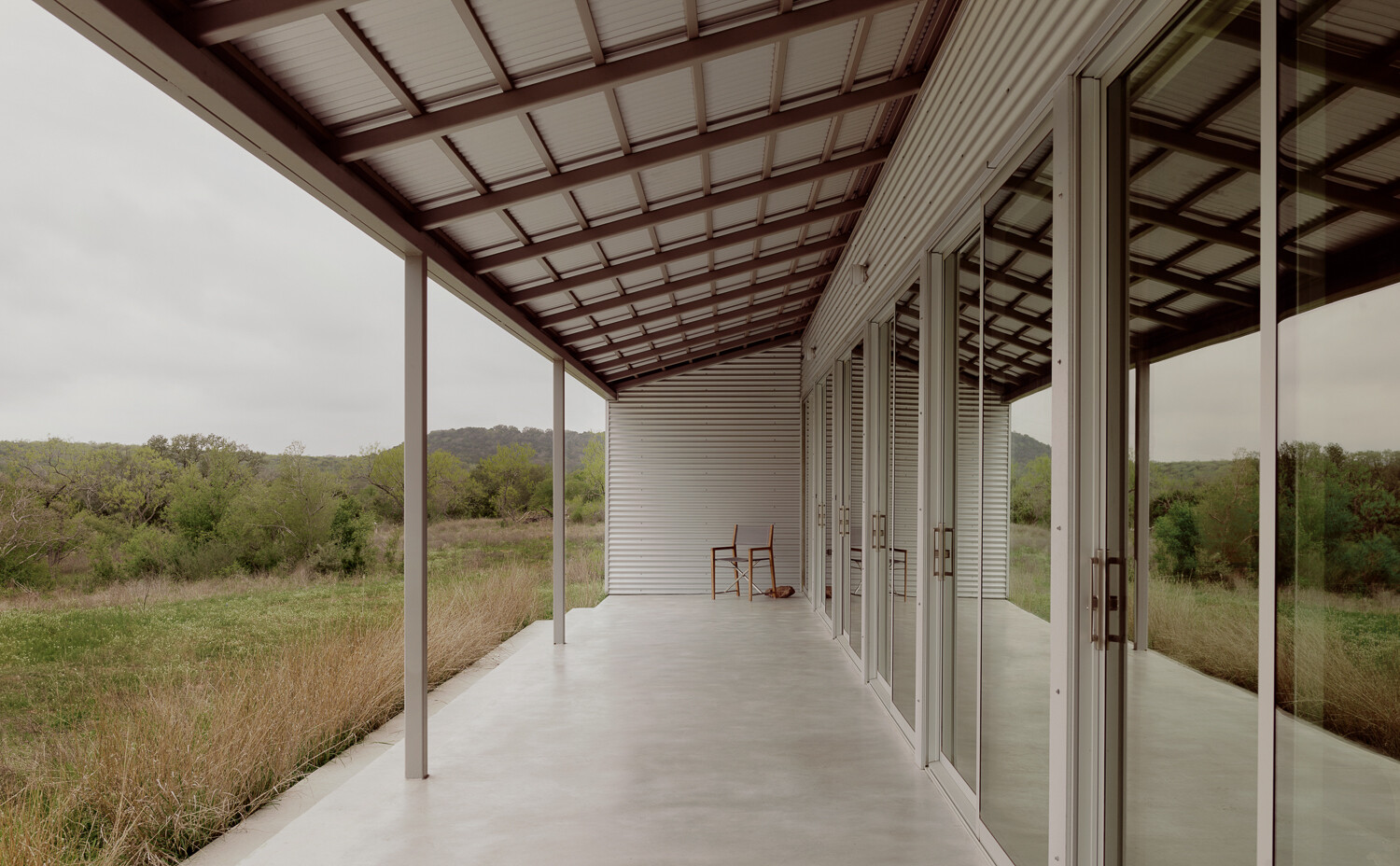 The overhanging roof creates covered outdoor space connected to the home's public areas.