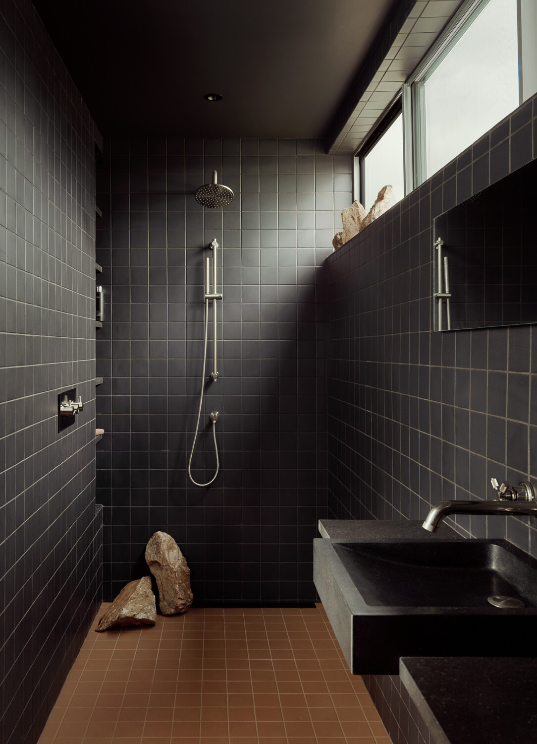 The main bathroom walls and shower are clad in tile, and illuminated with a clerestory window.