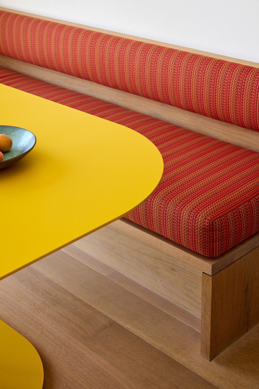 The breakfast nook's custom bench includes cushioning covered with Maharam Fabric. Its oak base matches the floors.