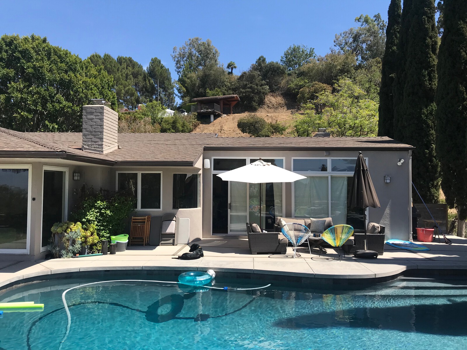 The existing house's outdoor patio came with a pool the family used frequently, but the lack of a roof overhang above the glass patio doors and clerestory windows often created glare inside.