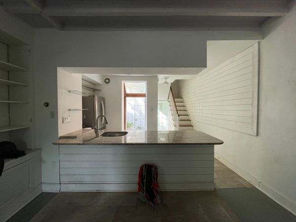 The original kitchen was cut off from the living room (in the foreground) by a large island and overhead cabinetry.