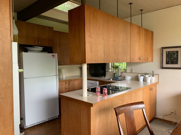 The kitchen, like in many midcentury-modern homes, was relatively closed off from the adjacent dining area, but the hanging upper cabinets above the peninsula counter were not in the original plans.