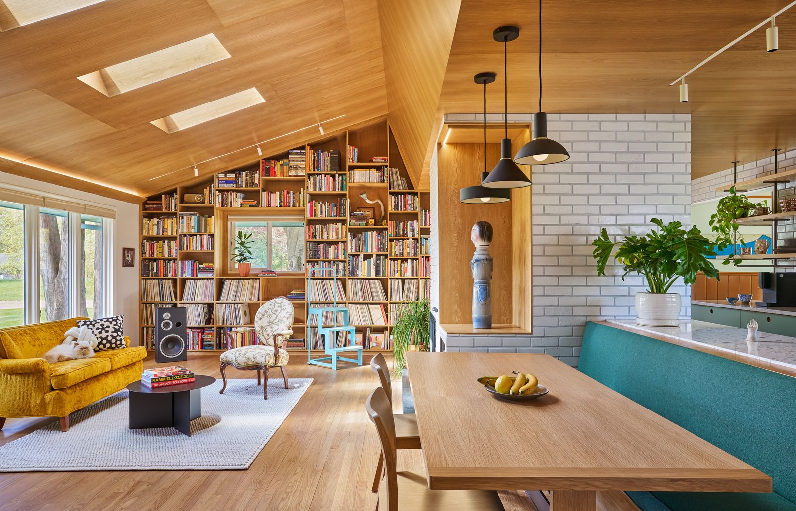 One of the couple's two cats, Casper, holds court on a recovered vintage sofa in this shot encompassing the living room, dining table and a portion of the kitchen.
