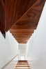 Walls were removed and a new open riser stair was stacked vertically along the party wall from the basement to the third floor, inviting light and air into the once light-devoid interior spaces. Photo 9 of Contrast House modern home