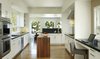 Modern home with Kitchen, Stone Counter, Dishwasher, Wall Oven, Wine Cooler, Medium Hardwood Floor, Recessed Lighting, White Cabinet, Range Hood, Undermount Sink, and Stone Slab Backsplashe. Potrero Residence Kitchen Photo 6 of Potrero House