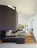 Modern home with Living Room, Pendant Lighting, Medium Hardwood Floor, Ottomans, Bench, Recessed Lighting, Two-Sided Fireplace, Sofa, Chair, Gas Burning Fireplace, Concrete Floor, Ceiling Lighting, and End Tables. Ridge House Photo 6 of Ridge House