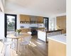 Modern home with Kitchen, Refrigerator, White Cabinet, Wood Cabinet, Engineered Quartz Counter, Range Hood, Range, Medium Hardwood Floor, Wood Counter, Recessed Lighting, and Wall Lighting. Ridge House Photo 8 of Ridge House